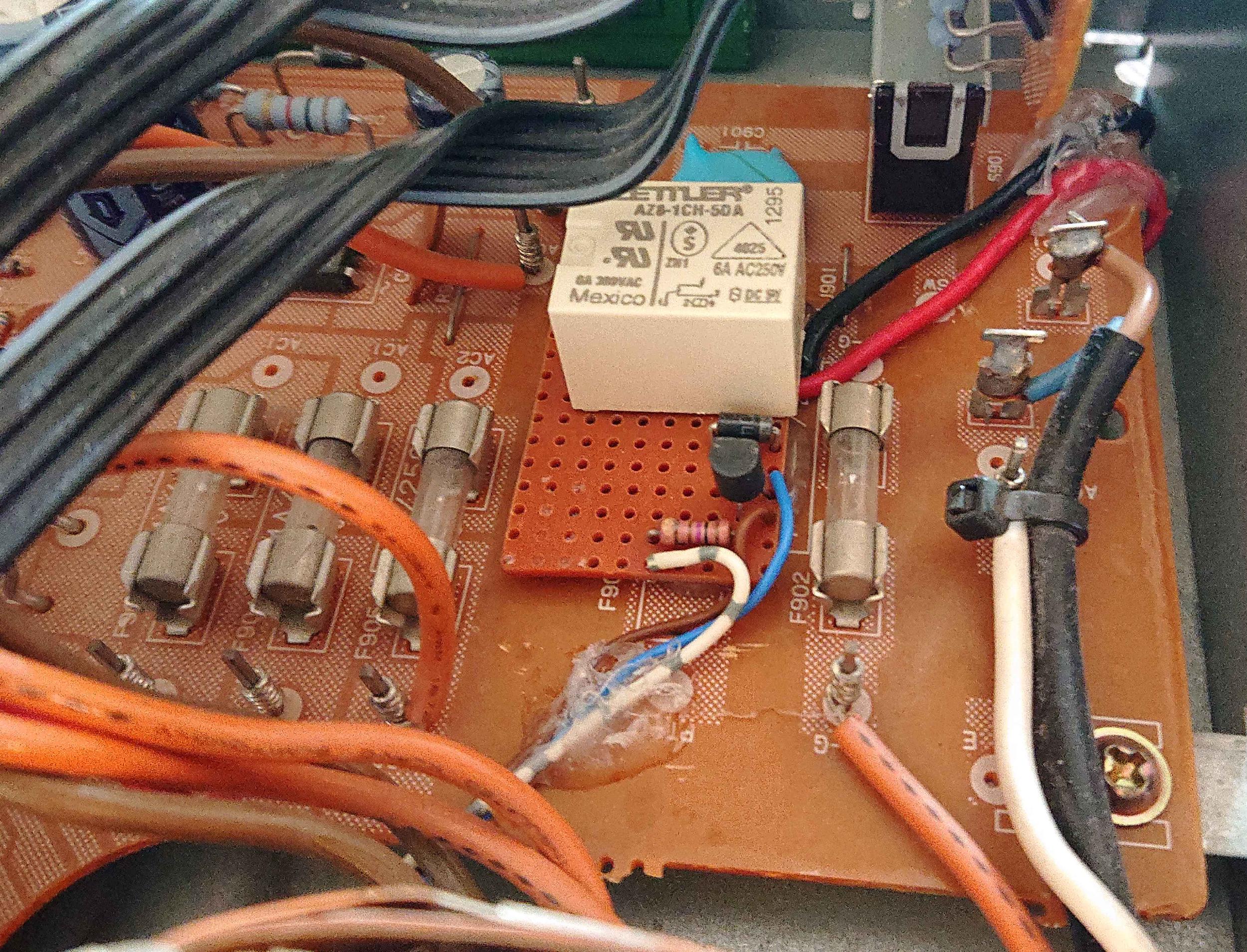 Relay and transistor along with a 
resistor soldered onto a piece of PCB perfboard material