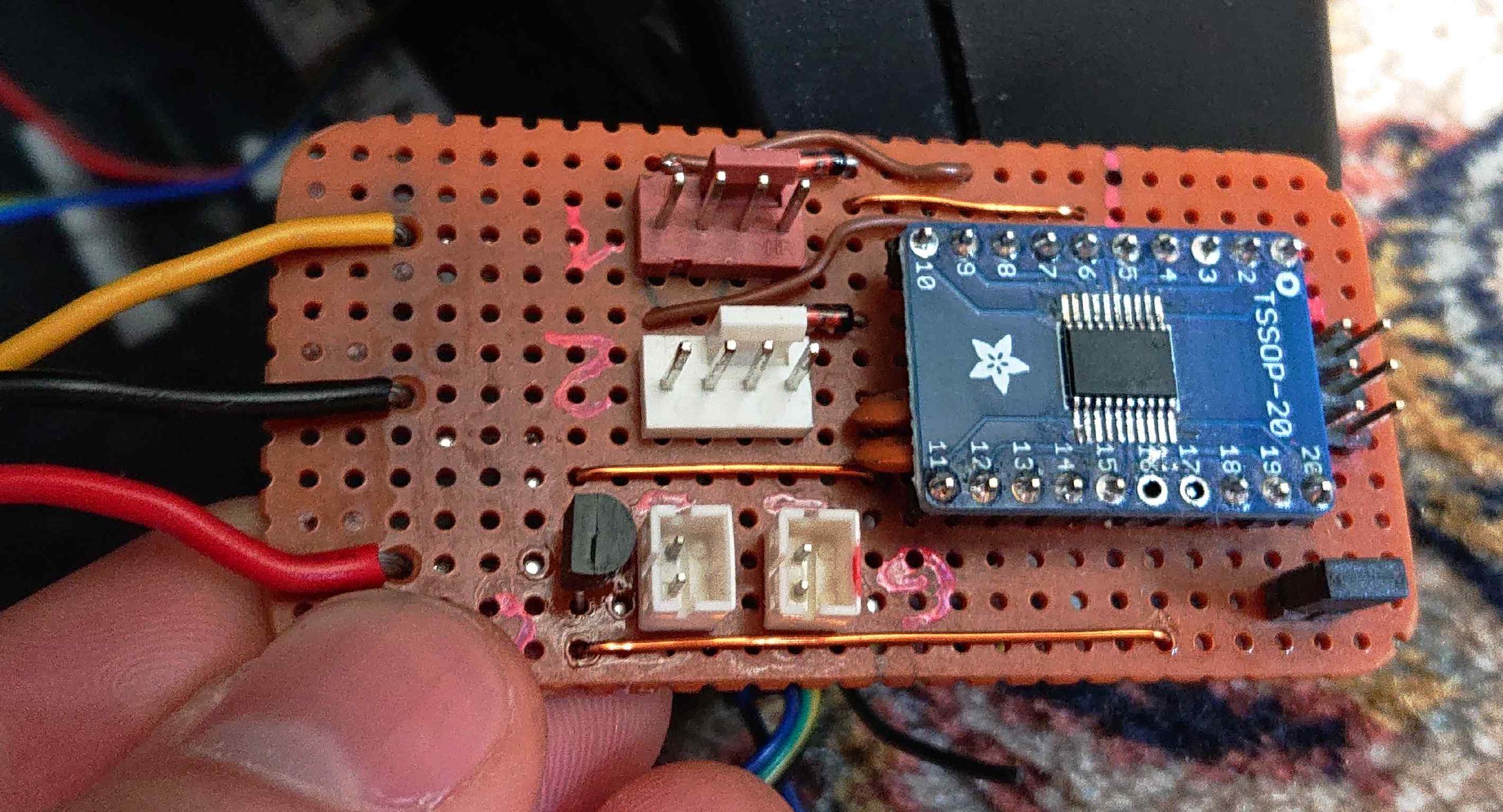 A strip of perfboard with electrical components and plugs soldered on